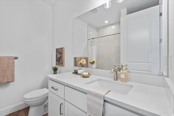 White vanity with an integrated sink, brushed nickel faucet, and a large wall-mounted mirror