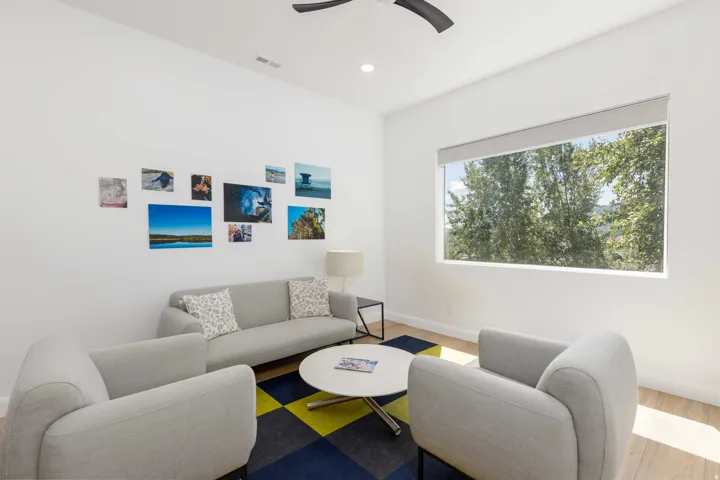 Recessed lighting, wood-finish flooring, ceiling fan, large window with roller shade
