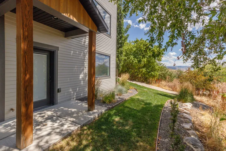 Modern exterior with horizontal siding, wood-finish columns, and a covered entry