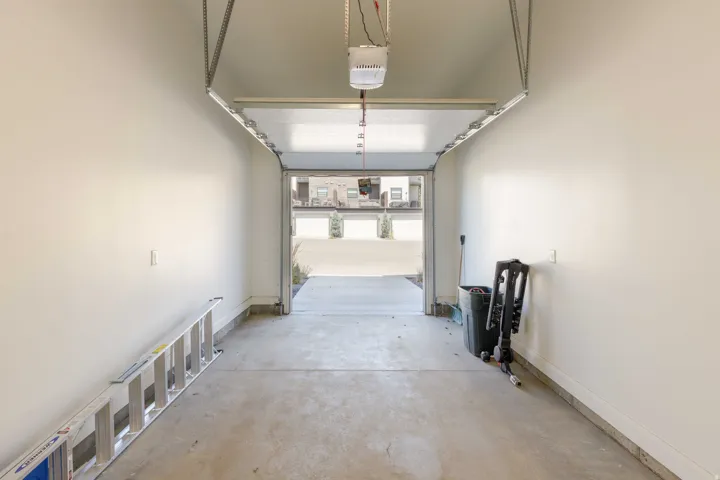 Attached garage with a concrete floor, painted walls, and an automatic garage door opener