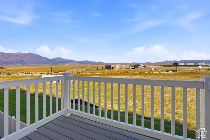 Deck with composite flooring and white railing, featuring expansive desert scenery and distant mountains