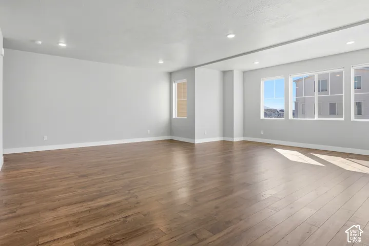 Expansive room featuring wood-finish flooring, recessed lighting, and multiple windows