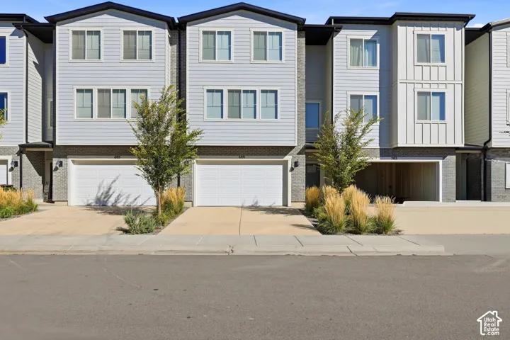Contemporary exterior with light-colored horizontal siding, dark trim, and a prominent two-car garage