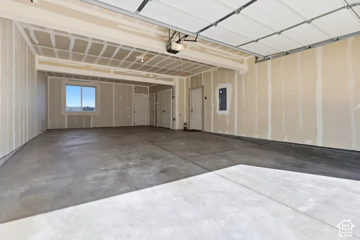 Unfinished garage interior with exposed studs, concrete flooring, and a single window