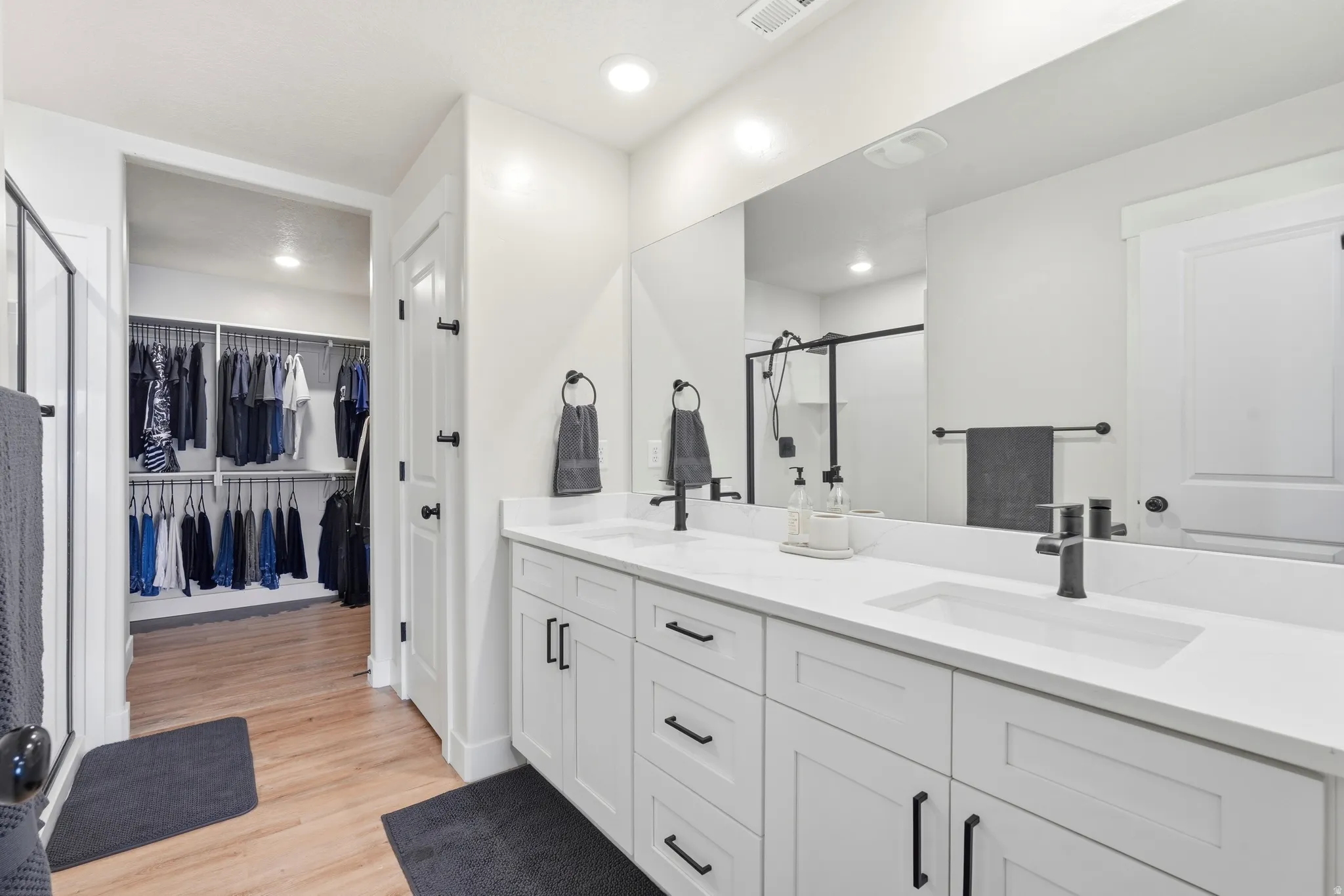 Dual vanity with white cabinetry and black hardware
