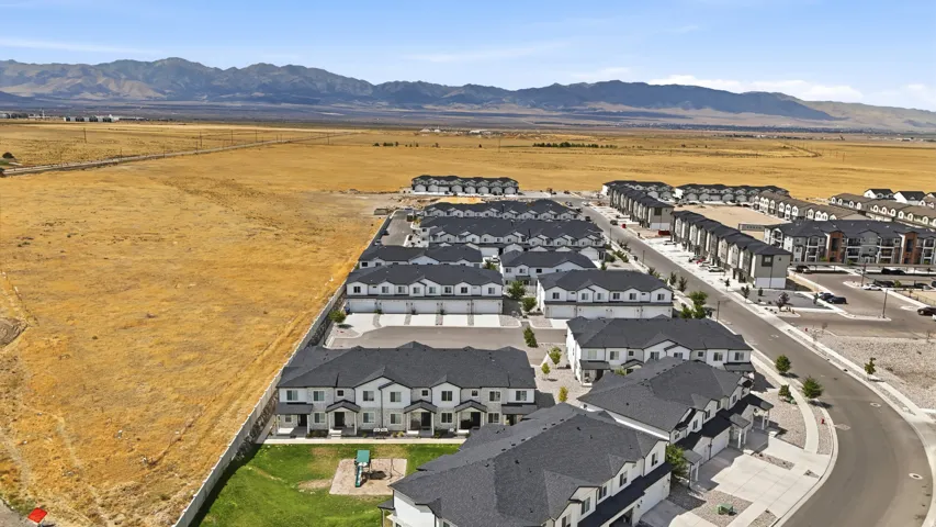 Modern townhome community with a playground, paved streets, and mountain backdrop