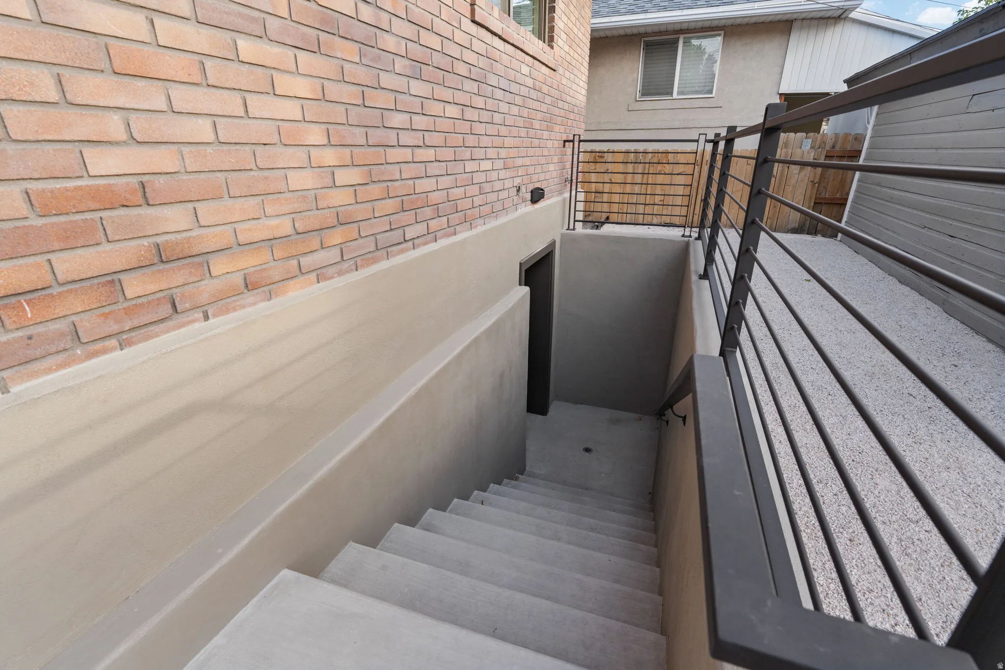 Brick exterior with concrete stairs and a metal railing