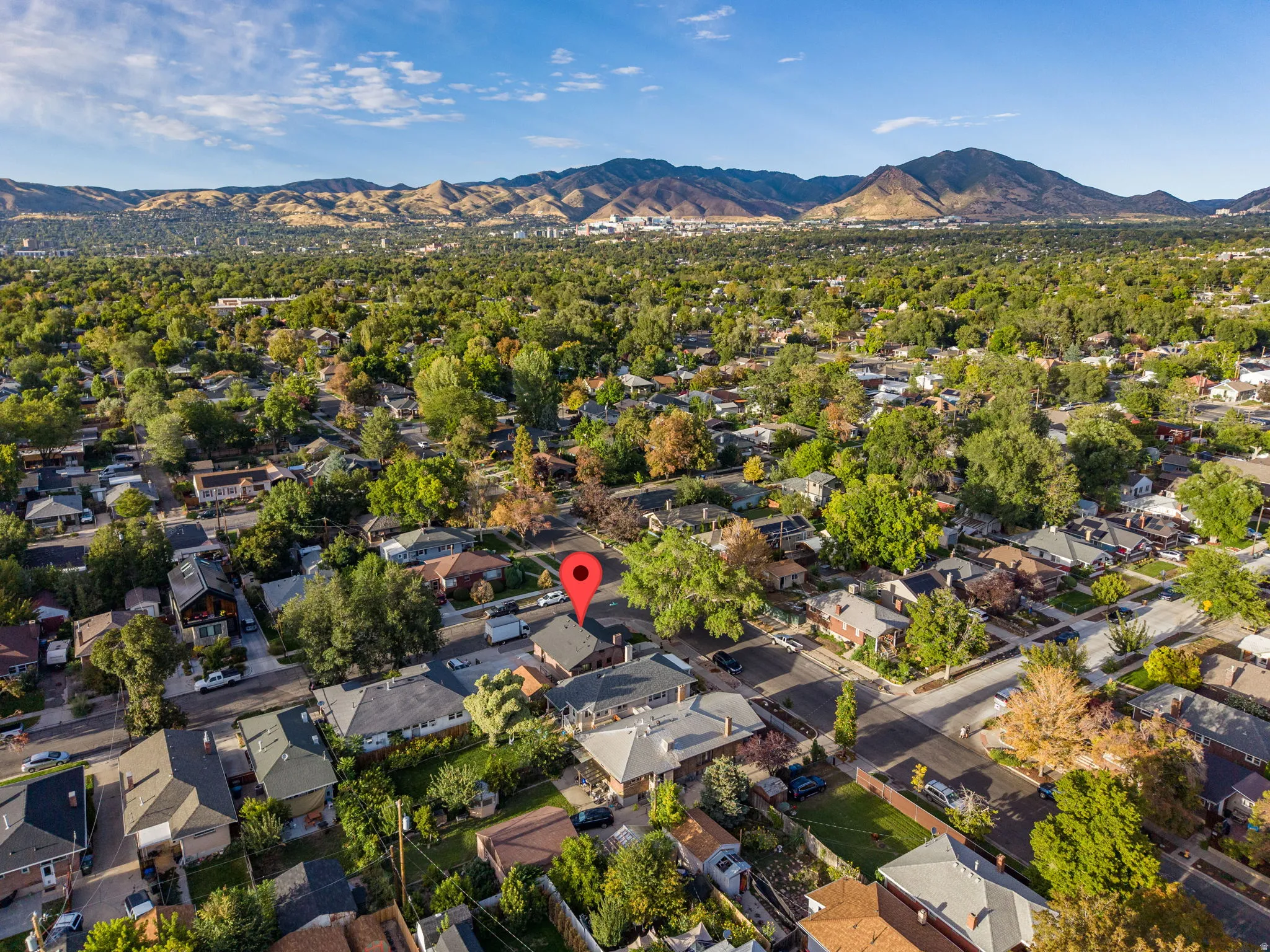 Neighborhood setting with mature trees and a distant mountain range