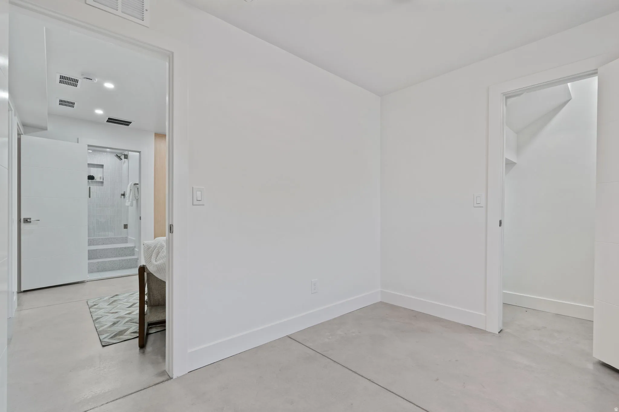 Concrete flooring throughout, white walls, and bright overhead lighting