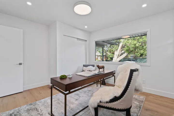 Recessed lighting, wood-finish flooring, white walls, and a built-in sliding closet door