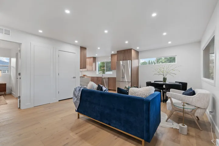 Open-concept living area featuring wood-finish flooring, recessed lighting, and white walls