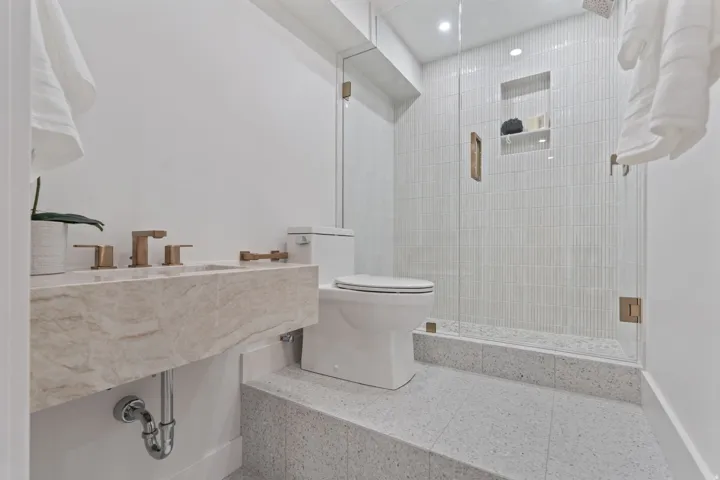 Floating stone vanity with bronze fixtures