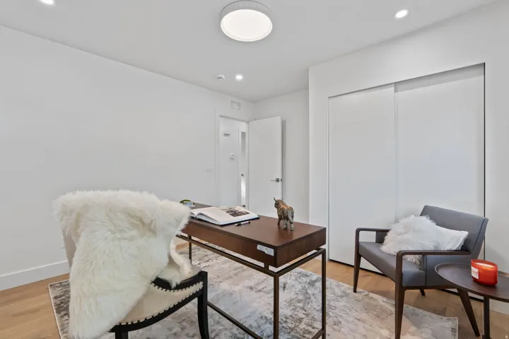 Recessed lighting, flush-mount ceiling light, light wood-finish flooring, white walls, and built-in sliding closet doors