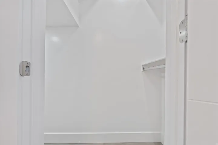 White interior with built-in shelving and hanging rod