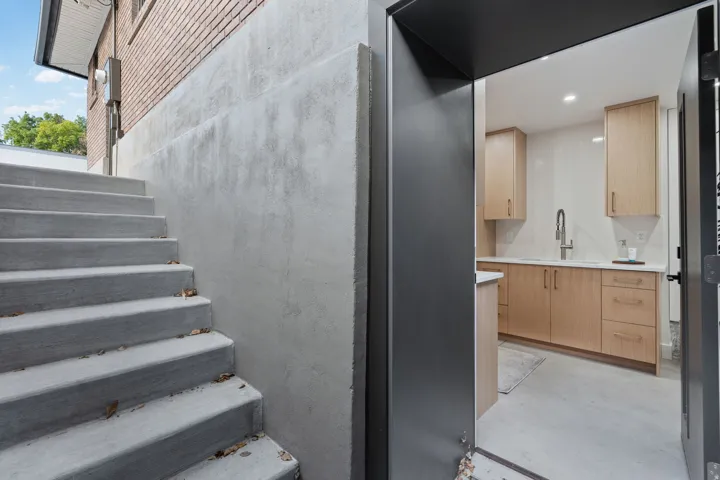 Concrete exterior stairs leading to a brick-clad structure