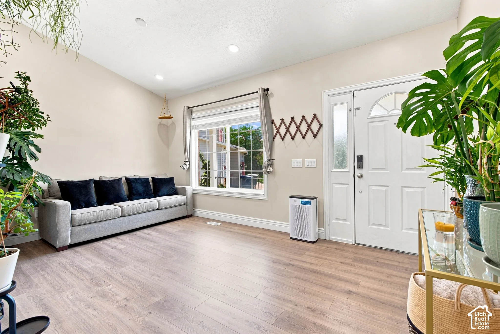 Vaulted ceilings and recessed lighting illuminate a spacious room featuring wood-finish flooring