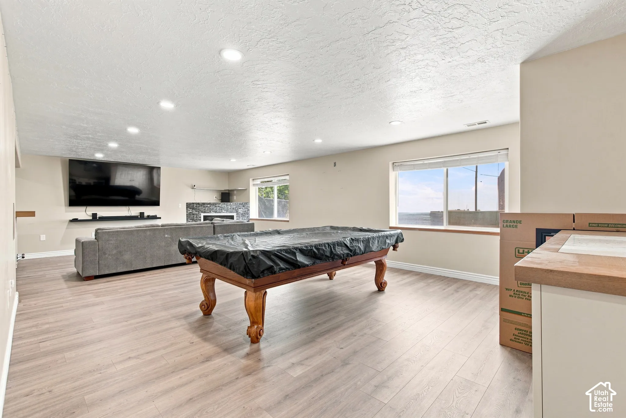 Expansive room featuring wood-finish flooring, recessed lighting, and a window providing natural light