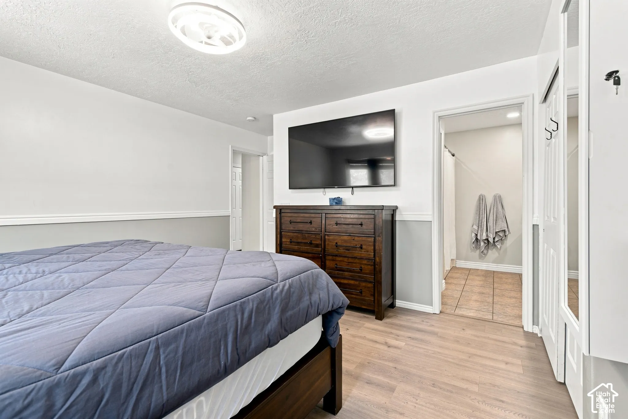 Wood-finish flooring, two-tone wall paint with chair rail, and a semi-flush mount ceiling light