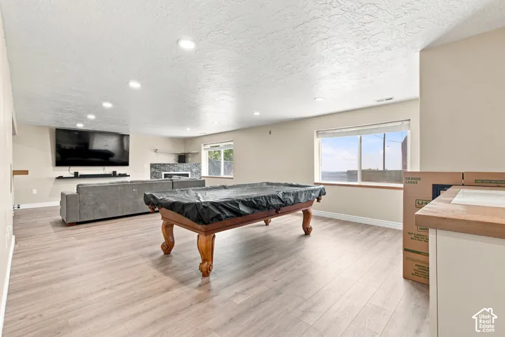 Expansive room featuring wood-finish flooring, recessed lighting, and a window providing natural light