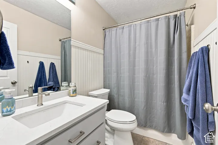 Vanity with integrated sink and brushed nickel faucet, beadboard wainscoting, and full mirror