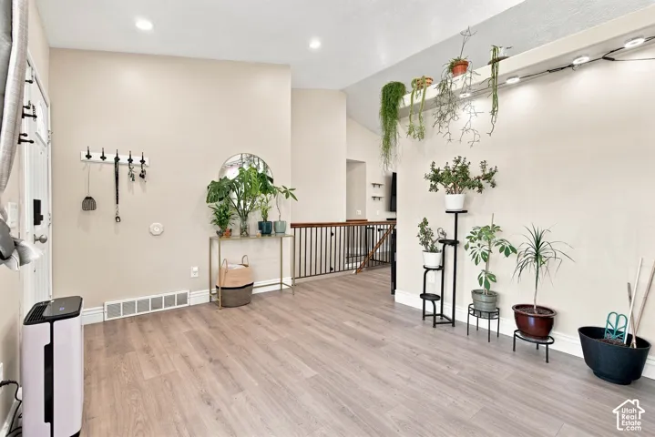 Wood-finish flooring with neutral wall tones and recessed lighting
