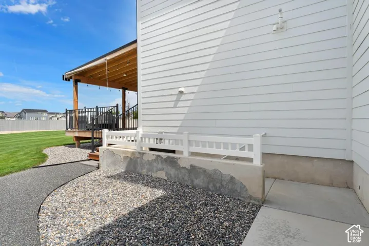 Covered deck featuring exposed wood beams and black metal railings