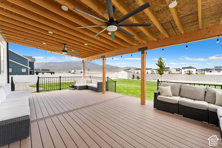 Expansive covered patio featuring wood-finish decking, exposed wood beam ceiling, recessed lighting, and ceiling fans