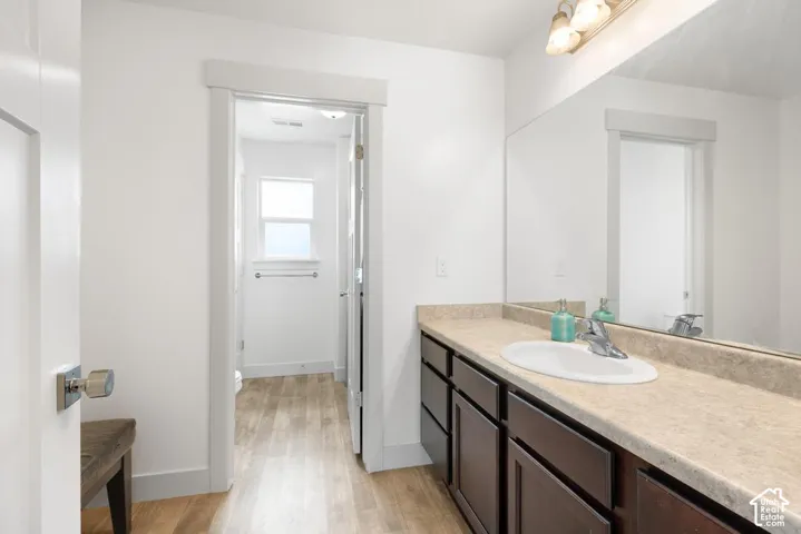 Vanity with an integrated sink, polished chrome faucet, and expansive mirror