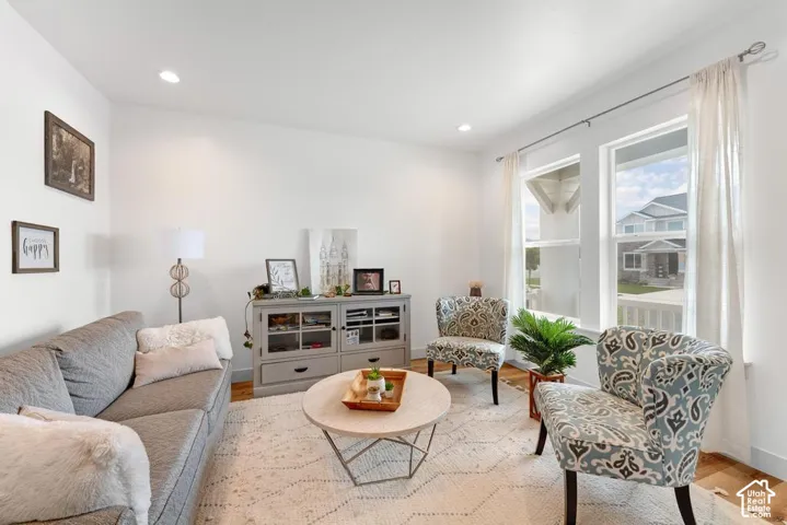 Recessed ceiling lighting, white walls, and wood-finish flooring