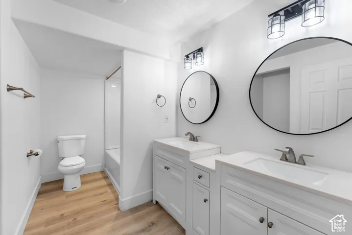 Dual vanity with white cabinetry, integrated sinks, and polished chrome fixtures