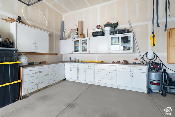Concrete flooring with extensive built-in cabinetry, overhead storage, and a wall-mounted charging station