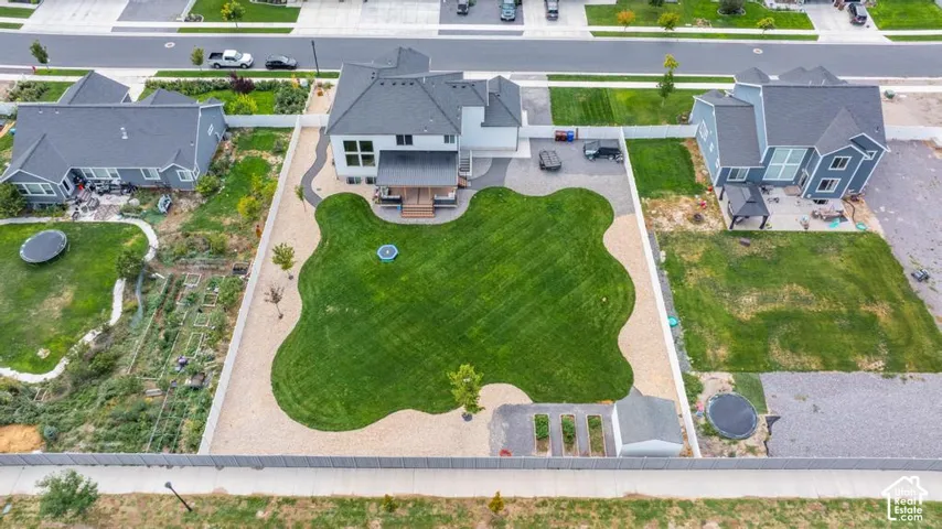 Expansive backyard featuring a manicured lawn, a detached storage shed, and a gravel perimeter