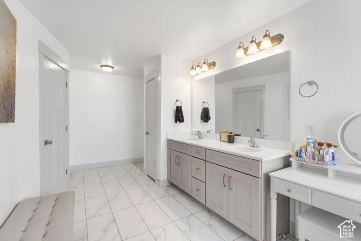 Dual vanity with undermount sinks, light gray cabinetry, and a large mirror