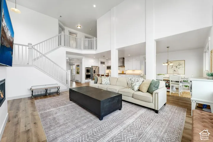 Two-story living area with wood-finish flooring, a built-in fireplace, and a second-story balcony