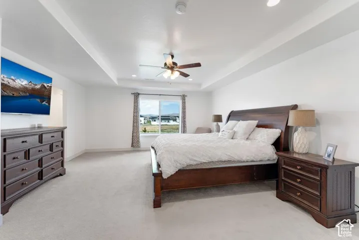 Recessed lighting, ceiling fan, tray ceiling, wall-to-wall carpeting, and expansive window
