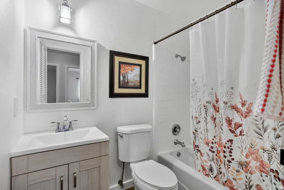 Bathroom featuring a single vanity with wood-finish cabinetry, a white countertop, and a chrome faucet