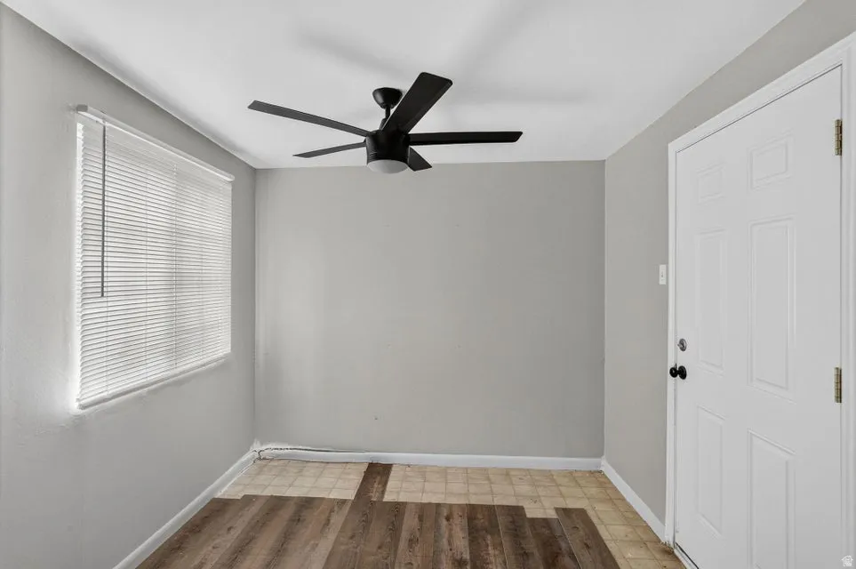 Room featuring a window with blinds, ceiling fan, and paneled door