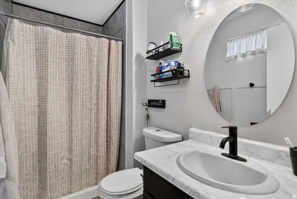 White countertop with integrated oval sink, matte black faucet, and an oval wall mirror