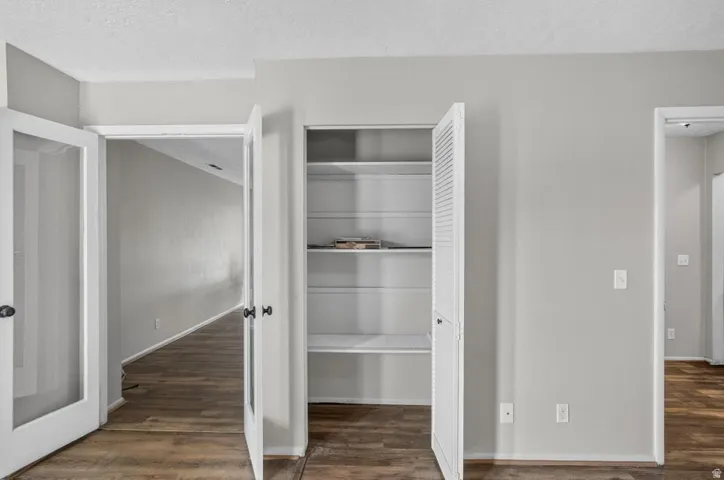 White louvered bifold doors concealing shelving