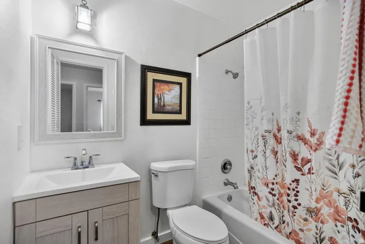 Bathroom featuring a single vanity with wood-finish cabinetry, a white countertop, and a chrome faucet