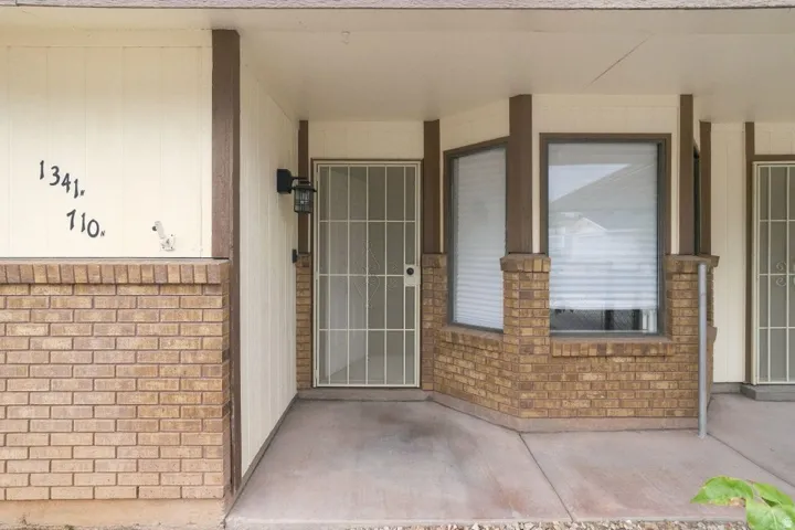Brick veneer exterior with vertical siding accents, secured entry door, and bay window feature