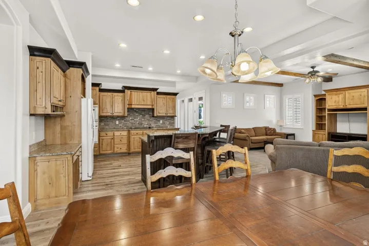 Kitchen featuring wood cabinetry, stone-finish backsplash, and recessed lighting