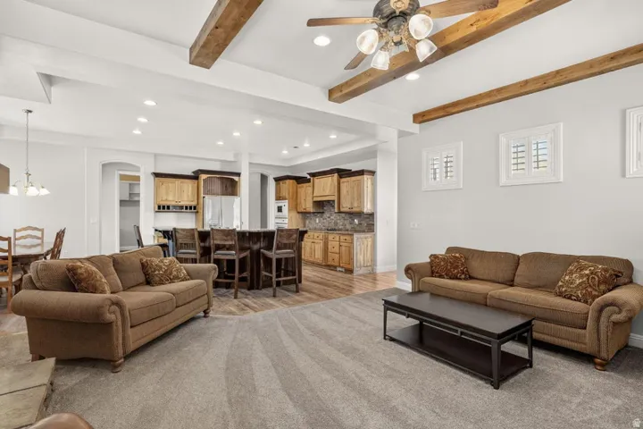 Vaulted ceilings featuring wood beams, recessed lighting, and a ceiling fan