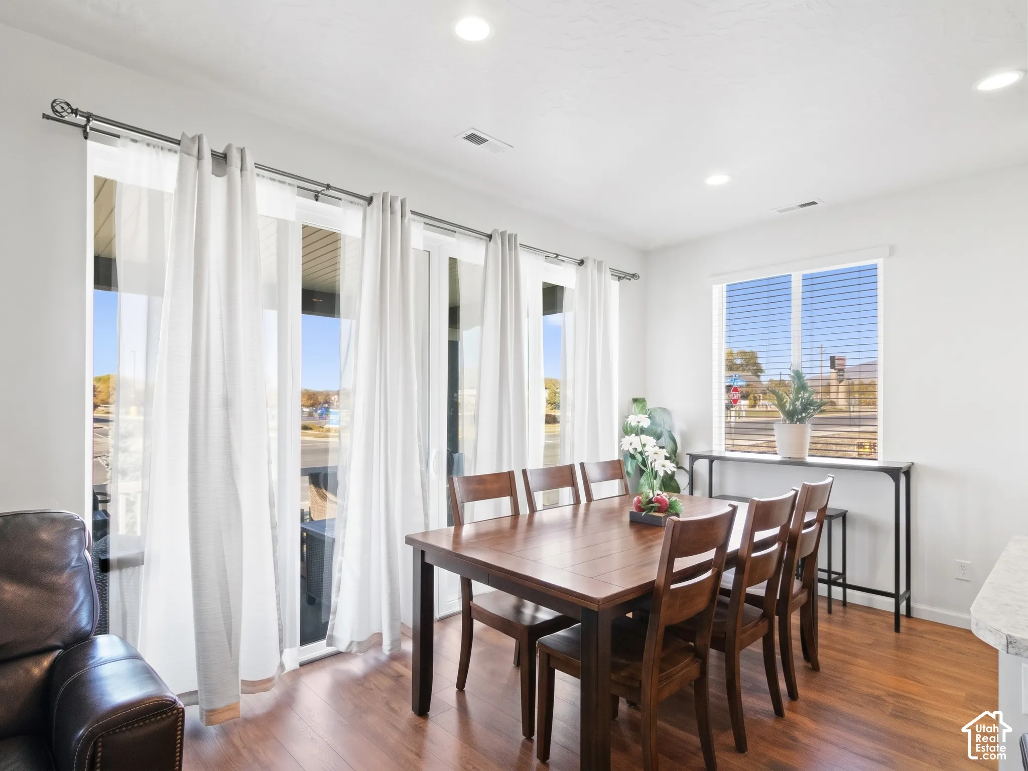 Wood-finish flooring, recessed lighting, and large sliding glass doors providing external access