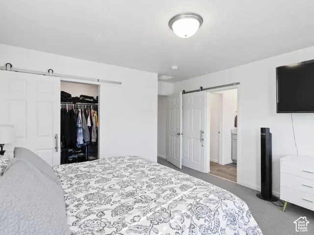 Recessed lighting fixture, white interior walls, barn door style closet, and an additional white panel door