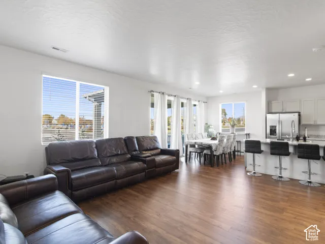 Open-concept living space featuring wood-finish flooring, recessed lighting, and large windows