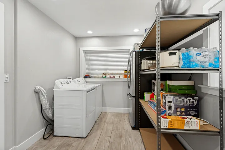 Recessed lighting, wood-finish flooring, and a large window with blinds