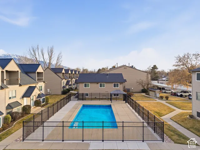 Fenced-in outdoor pool with surrounding concrete patio