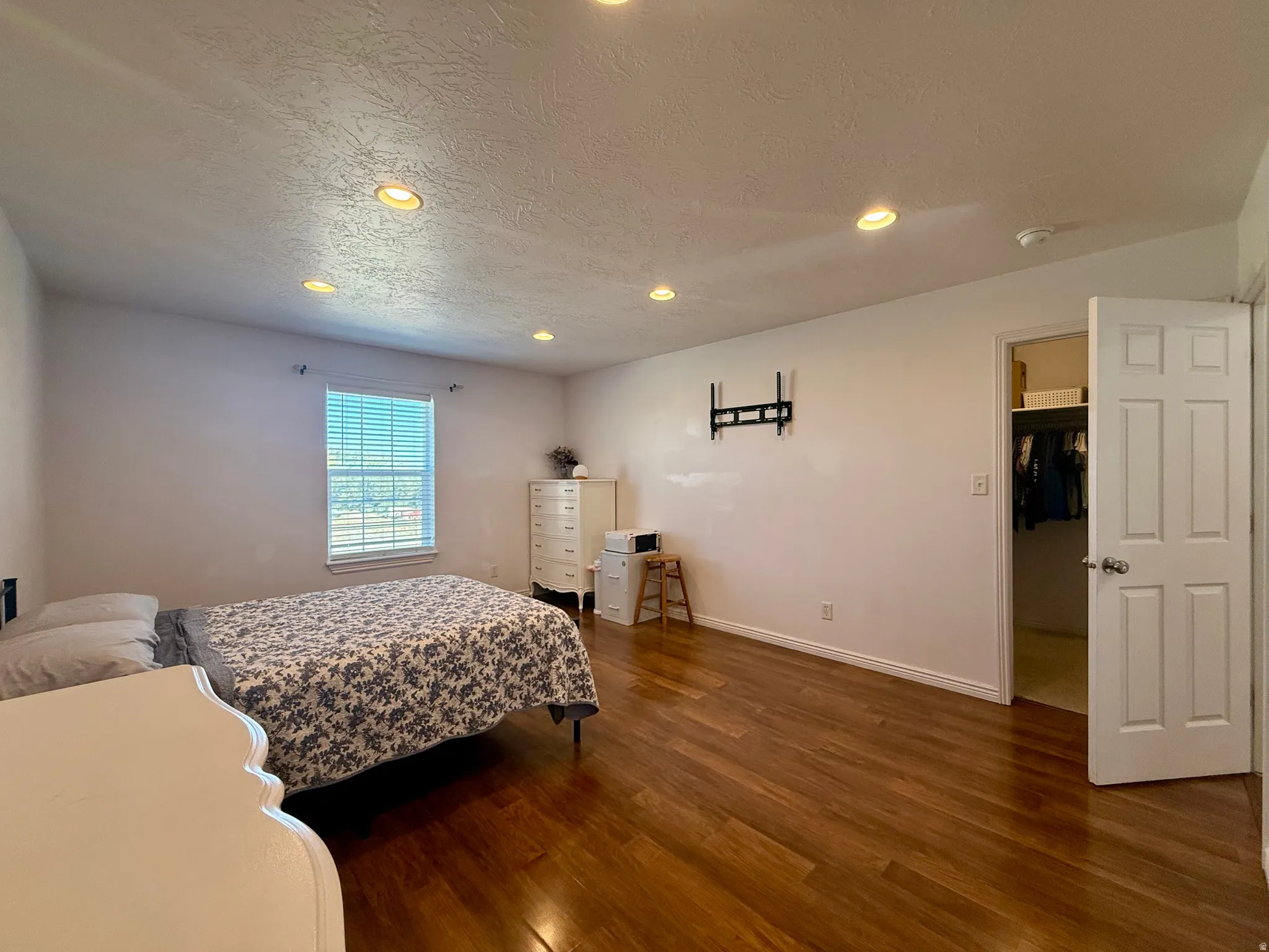 Recessed ceiling lighting, hard-surface flooring, window with blinds, and an open closet