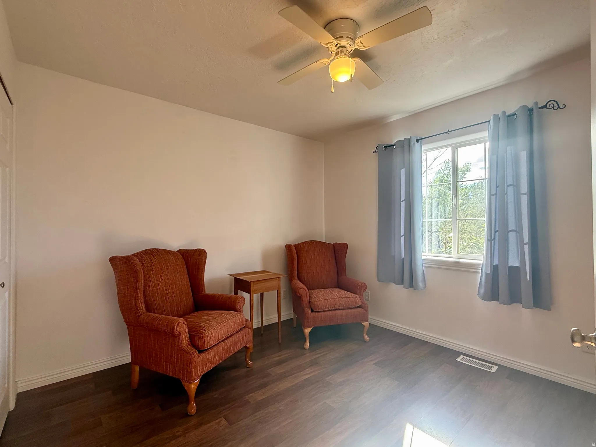 Wood-finish flooring, ceiling fan with integrated lighting, and a single window